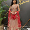 Woman wearing red and gold embroidered Indian lehenga with dupatta in Anandi Fashions boutique