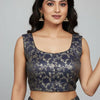 Woman wearing navy blue and gold floral brocade ethnic blouse and lehenga with jhumka earrings