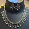 Traditional Indian oxidized silver necklace and matching floral earrings with pearl dangles on black display