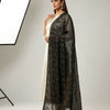 Model in white ethnic kurta with intricate pattern and sheer black embroidered dupatta, studio background