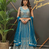 Woman in blue and silver embroidered lehenga with matching dupatta and traditional jewelry at Anandi Fashions