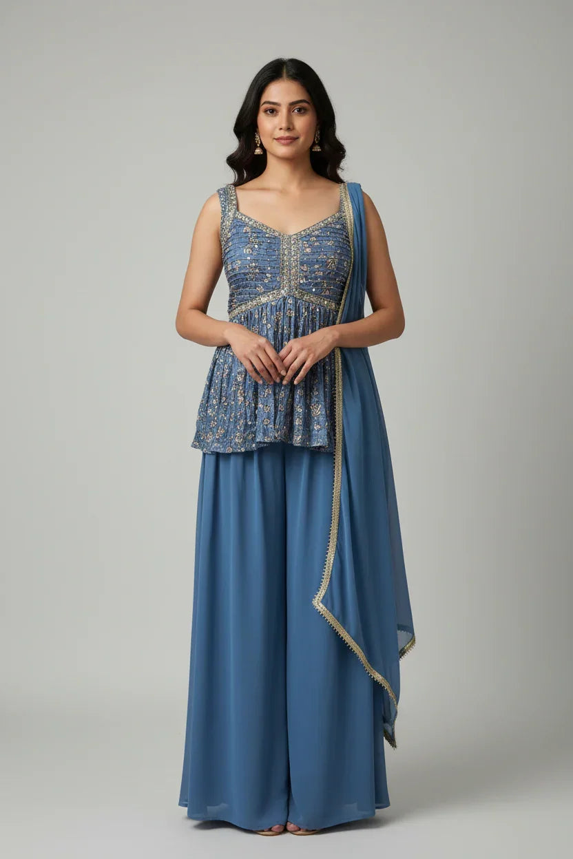 Woman wearing blue embroidered sleeveless ethnic top with matching palazzo pants and dupatta