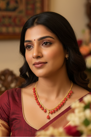 Indian woman in maroon silk saree wearing traditional red and gold necklace and earrings, elegant ethnic jewelry