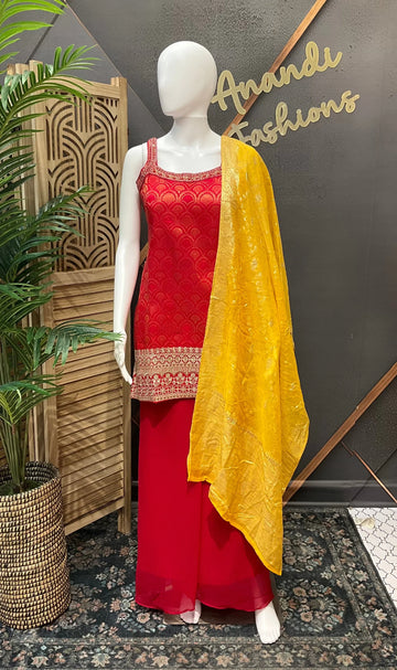 Mannequin wearing red Indian ethnic wear with gold embroidery and a yellow dupatta at Anandi Fashions boutique