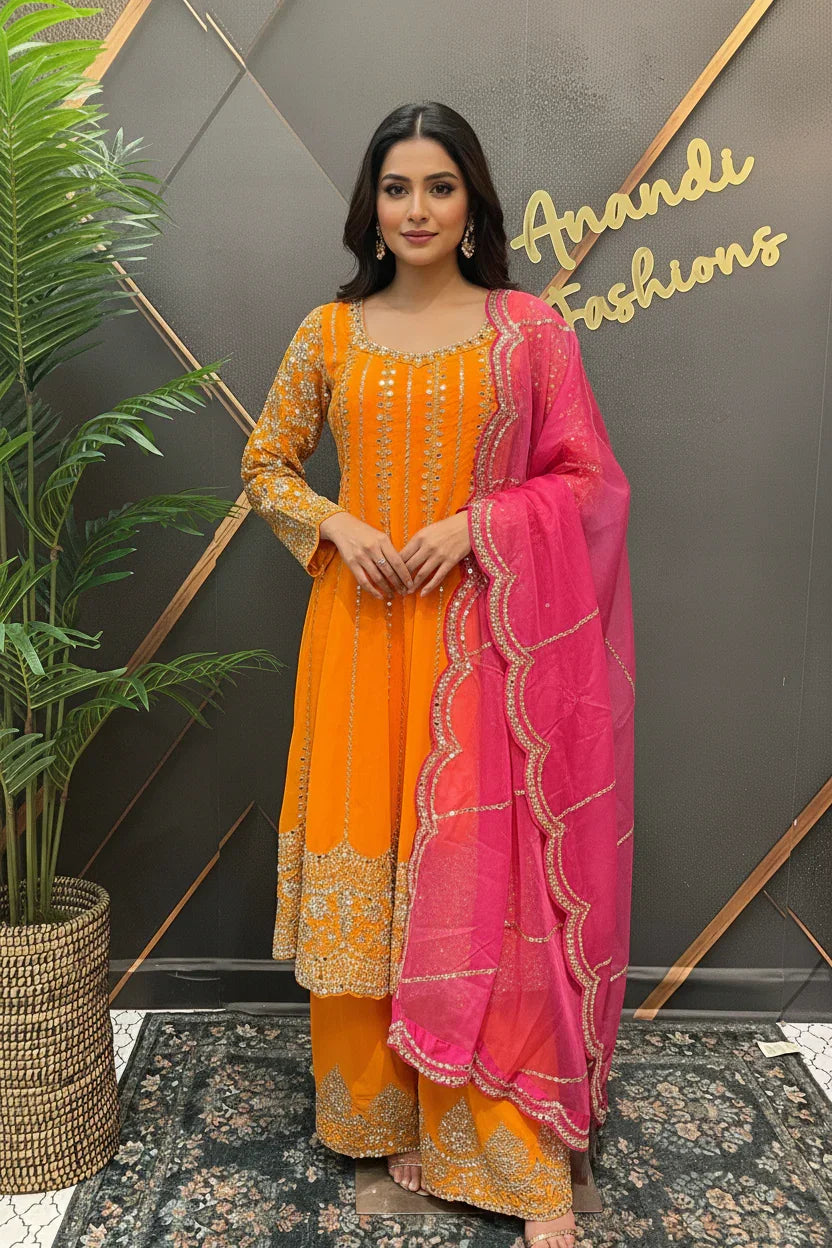 Woman in orange embellished Indian ethnic wear with pink dupatta at Anandi Fashions boutique
