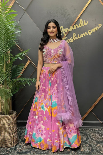 Woman in pink floral lehenga choli with sheer dupatta, standing indoors at Anandi Fashions boutique