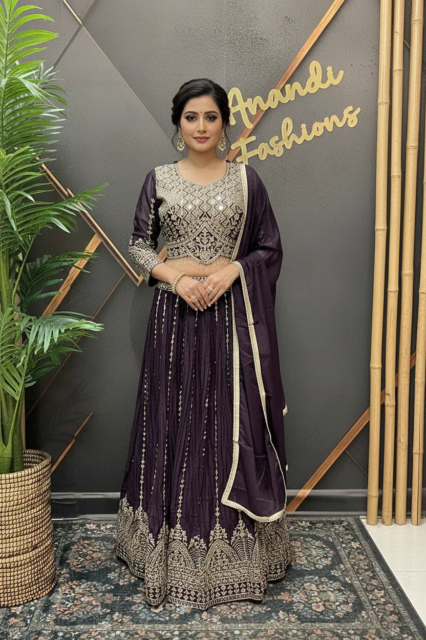 Woman modeling purple embellished lehenga choli with matching dupatta at Anandi Fashions boutique