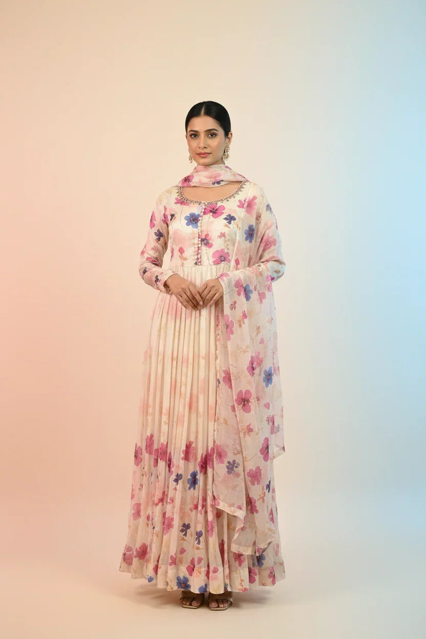 Woman wearing a cream floral printed Indian ethnic anarkali dress with dupatta and earrings