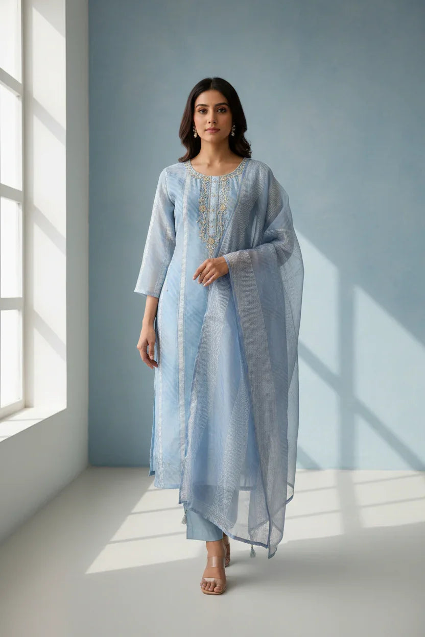 Woman in light blue Indian ethnic wear salwar kameez with embroidered neckline and sheer dupatta