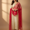 Woman in elegant cream and gold embroidered Indian ethnic suit with red embellished dupatta and gold earrings
