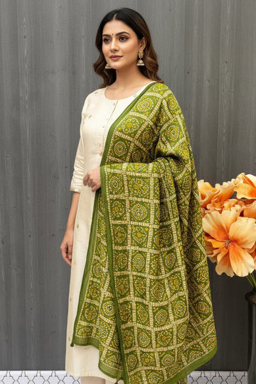 Woman wearing a white ethnic kurta with an olive green patterned Indian dupatta at Anandi Fashions
