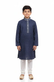 Young boy wearing navy blue checked kurta with embroidery and white churidar pants
