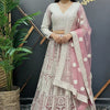 Woman wearing embroidered white and pink Indian lehenga with floral dupatta at Anandi Fashions boutique