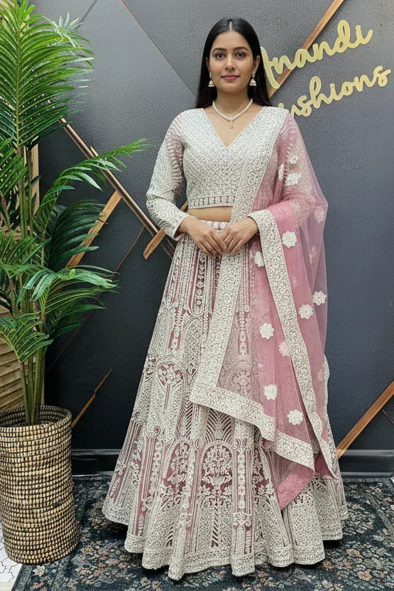 Woman wearing embroidered white and pink Indian lehenga with floral dupatta at Anandi Fashions boutique