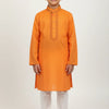 Boy wearing vibrant orange embroidered kurta with white churidar pants in studio