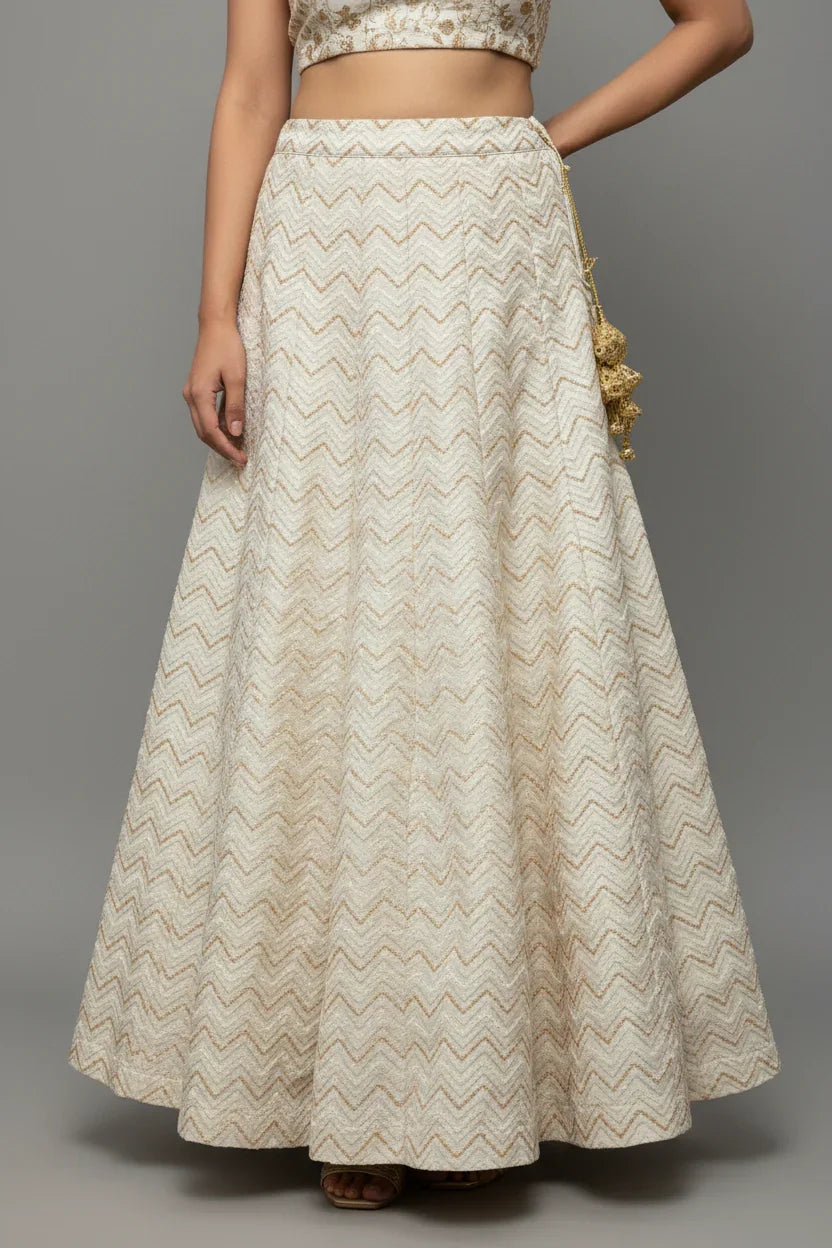 Close-up of woman wearing beige Indian ethnic skirt with zigzag pattern and decorative tassels