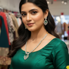 Woman in green ethnic blouse wearing elegant jewelry including emerald and diamond necklace and earrings at Anandi Fashions