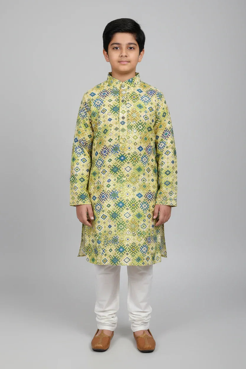 Boy wearing yellow and green patterned Indian ethnic kurta with white churidar and brown jutti shoes