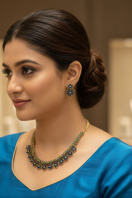 Close-up of woman in blue ethnic wear showcasing gold and blue floral necklace and matching earrings