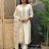 Woman wearing elegant cream Indian ethnic suit with embroidered dupatta at Anandi Fashions store