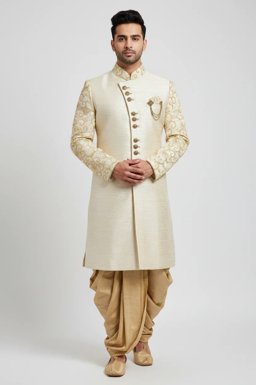Man wearing cream and gold embroidered Indian sherwani with matching dhoti pants and traditional juttis