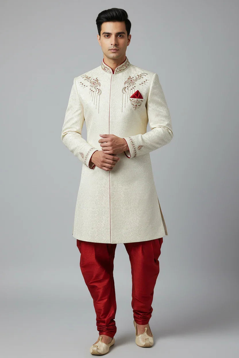 Man wearing cream embroidered sherwani with red churidar pants and matching pocket square, traditional Indian ethnic wear