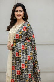 Woman wearing cream Indian ethnic kurta with gold embroidery and multicolor patterned dupatta, gold jhumka earrings