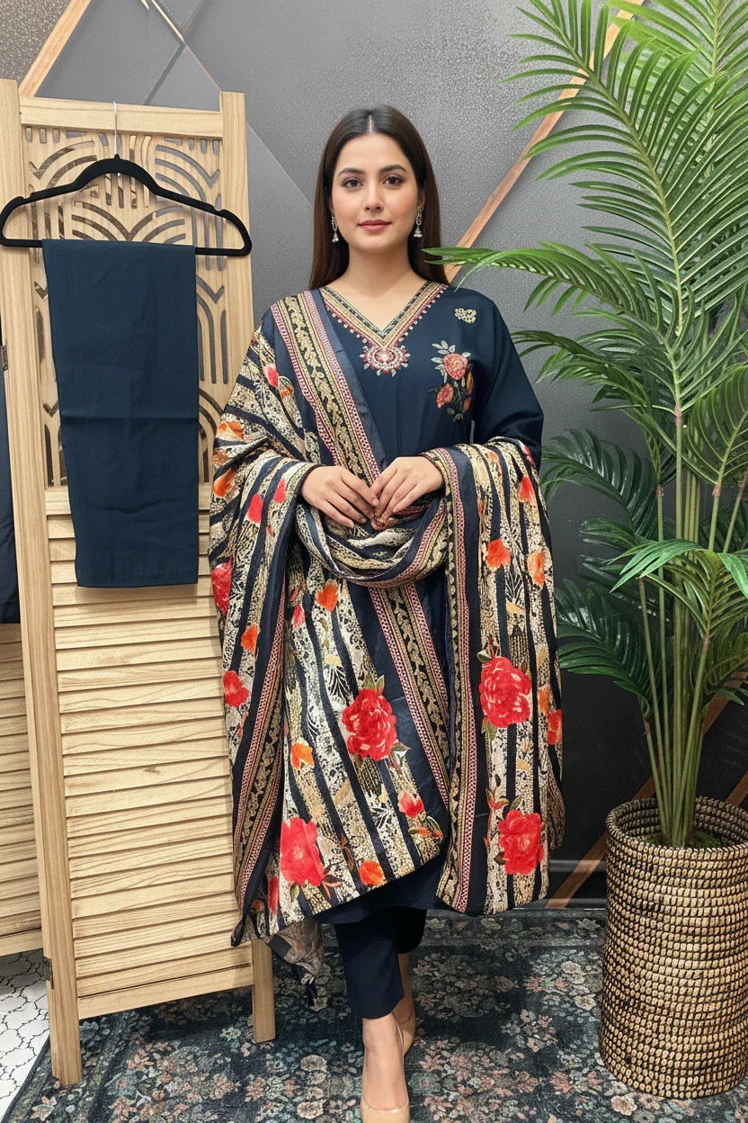 Woman in navy blue ethnic suit with embroidered floral patterns and striped floral dupatta, standing indoors