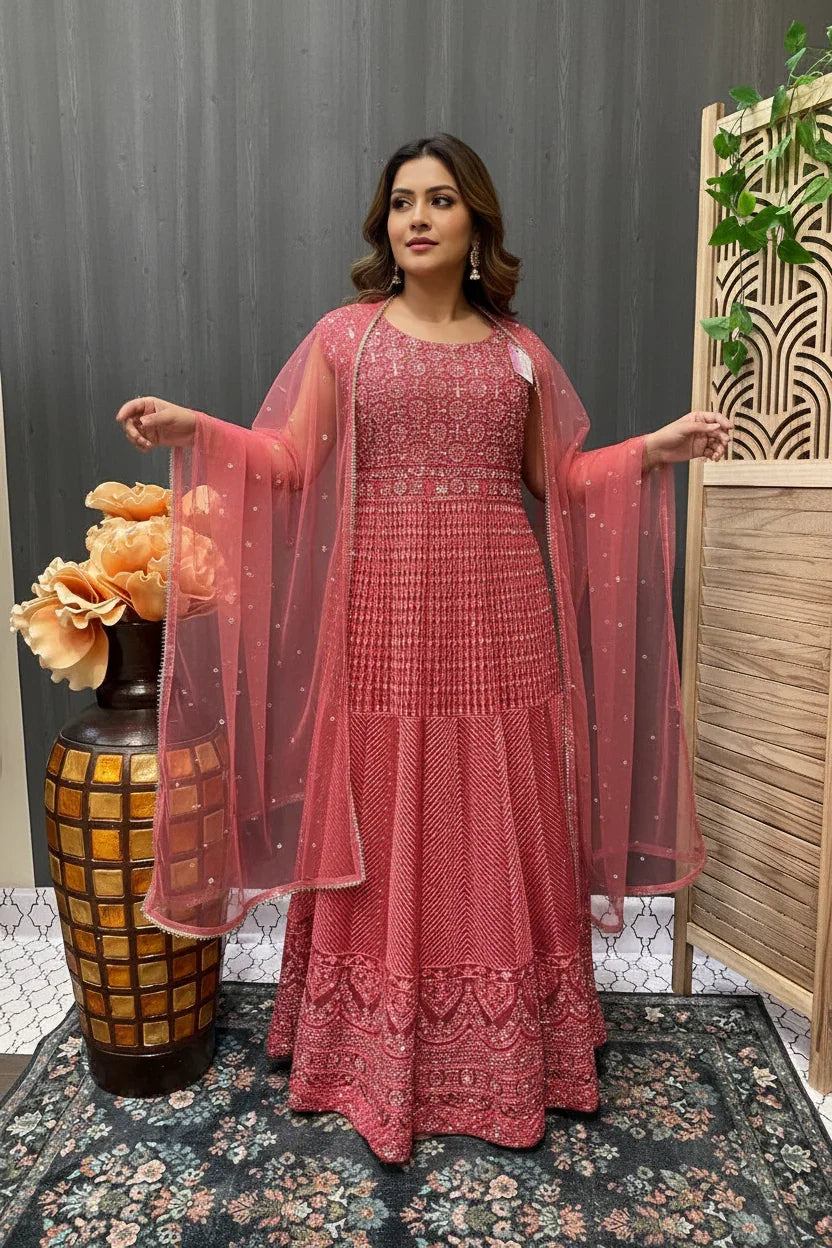 Woman wearing intricately embroidered red Indian ethnic gown with matching sheer dupatta at Anandi Fashions