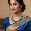 Elegant Indian woman in blue silk saree with silver jewelry and traditional makeup, showcasing ethnic fashion