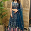 Woman wearing navy blue embroidered Indian lehenga with floral patterns and sheer dupatta in boutique