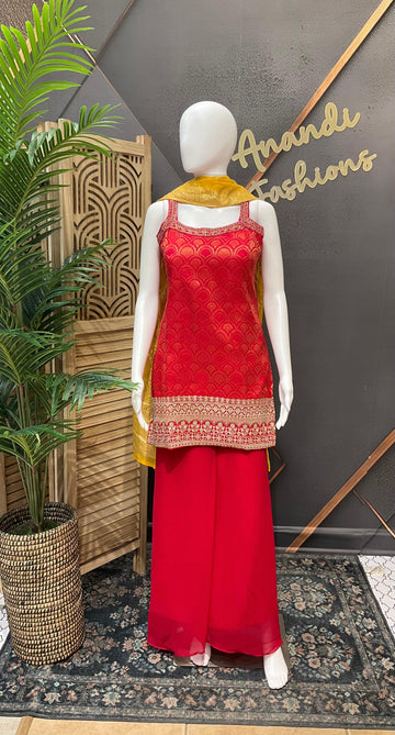 Mannequin wearing red Indian ethnic wear with gold embroidery and yellow dupatta inside Anandi Fashions store