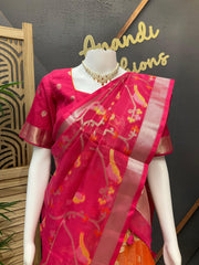 Pink Indian saree with floral and bird motifs on a mannequin, paired with gold-tone blouse and necklace at Anandi Fashions
