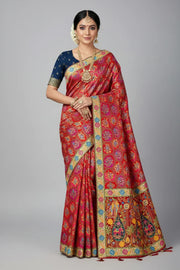Woman in red and gold Indian ethnic saree with traditional jewelry and navy blouse, studio background
