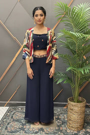 Woman in stylish Indian ethnic outfit with navy crop top, printed jacket, and palazzo pants at Anandi Fashions
