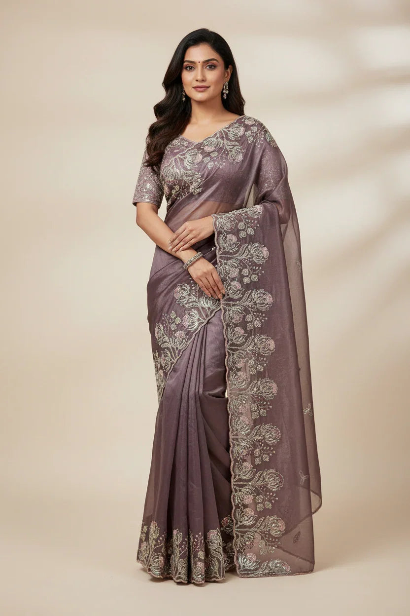 Woman wearing elegant mauve Indian saree with silver floral embroidery, styled with matching blouse and jewelry