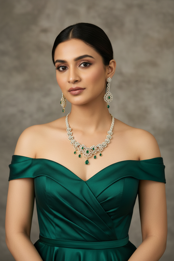 Elegant woman in off-shoulder emerald green dress wearing intricate diamond and emerald jewelry set