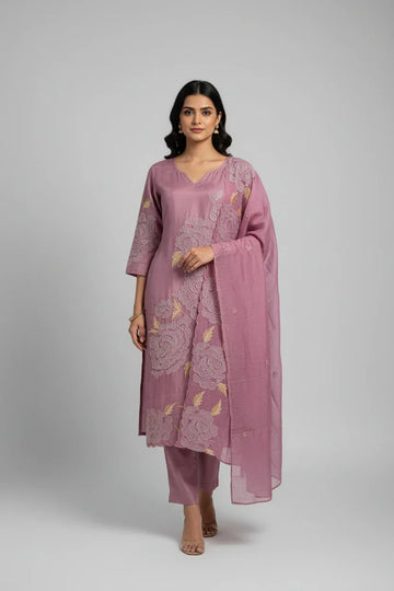 Woman wearing a purple Indian ethnic suit with floral embroidery and matching dupatta, posing in studio