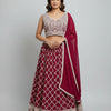 Woman wearing maroon and beige embroidered Indian lehenga with sleeveless blouse and matching dupatta