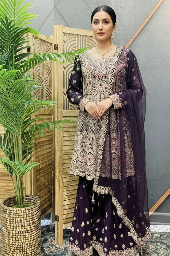 Woman wearing a purple heavily embroidered Indian ethnic suit with matching dupatta at Anandi Fashions boutique