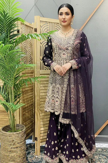 Woman wearing a purple heavily embroidered Indian ethnic suit with matching dupatta at Anandi Fashions boutique