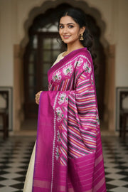 Smiling woman in traditional Indian saree with pink and white elephant patterns, standing in elegant hallway