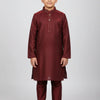 Young boy wearing maroon Indian ethnic kurta pajama with embroidery and golden traditional jutti shoes