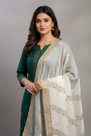 Woman wearing green Indian ethnic kurta with intricate golden embroidery and a white dupatta with gold patterns