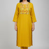 Woman wearing mustard yellow Indian ethnic kurta with floral embroidery and matching pants