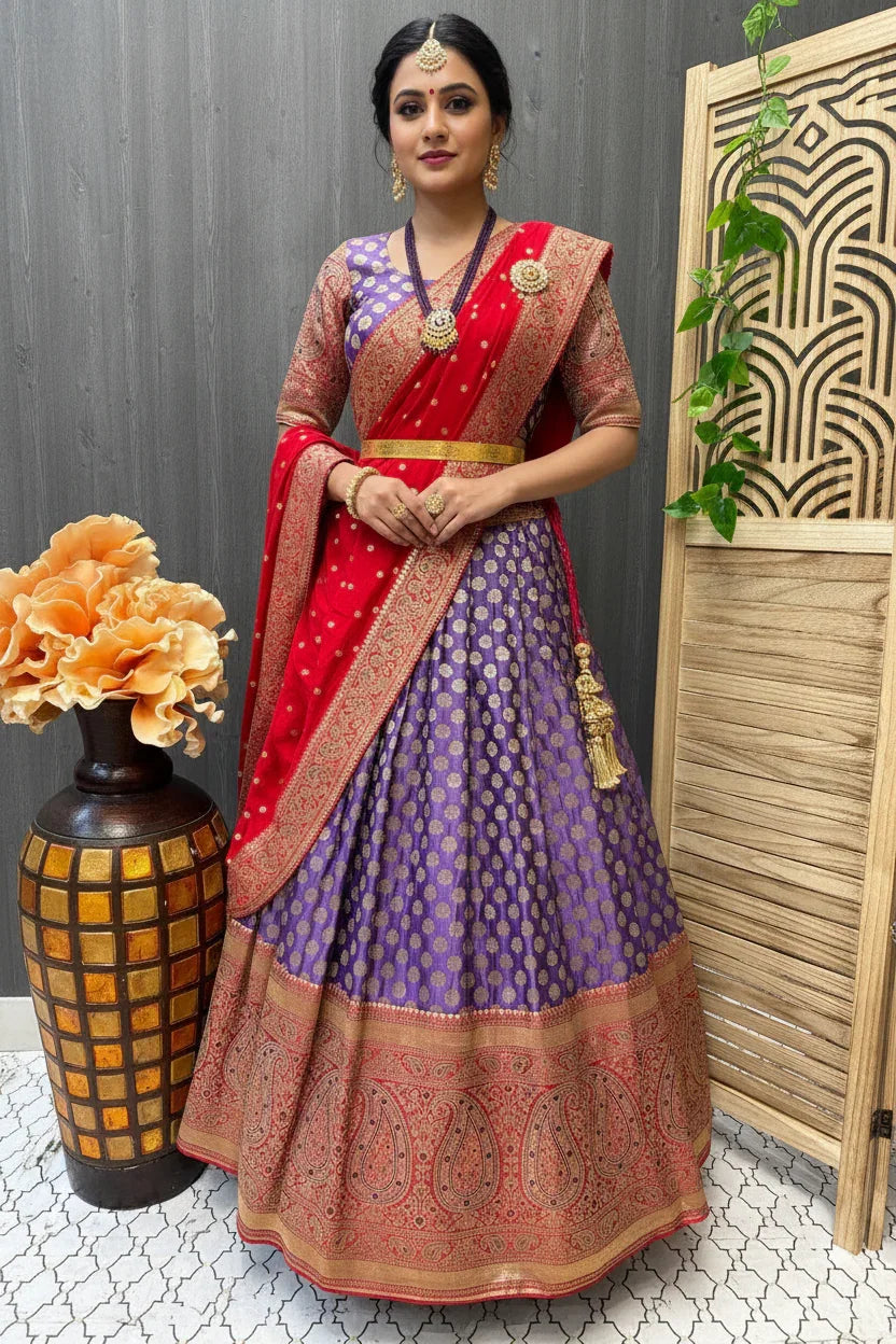 Woman in purple and gold Indian lehenga with red and gold dupatta, traditional jewelry, standing indoors