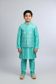 Boy in turquoise Indian ethnic wear kurta set with gold embroidery and beige traditional shoes