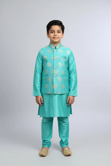 Boy in turquoise Indian ethnic wear kurta set with gold embroidery and beige traditional shoes