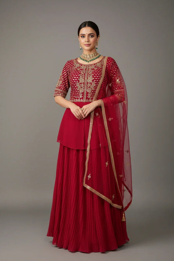 Woman wearing red Indian ethnic lehenga with gold embroidery and matching dupatta, styled with jewelry