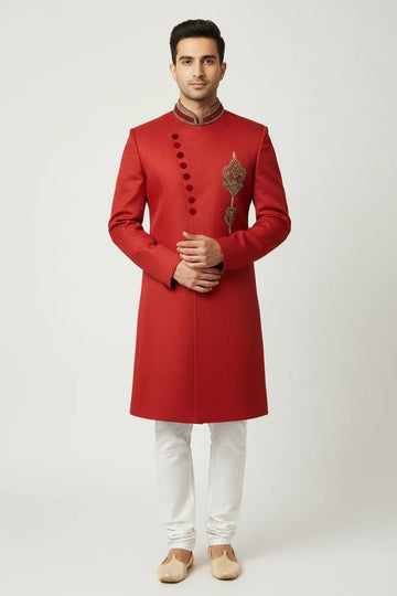 Man wearing red Indian sherwani with embroidery and white churidar pants, traditional ethnic wear